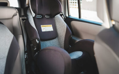 car-seat Child car seat installed in the back seat of a car, representing a defective seat that failed to protect a child in a side-impact collision.