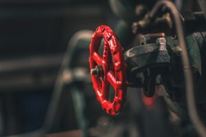 Close-up of a red metal valve, representing the defective fire hose valve that caused severe injuries in a product liability case.