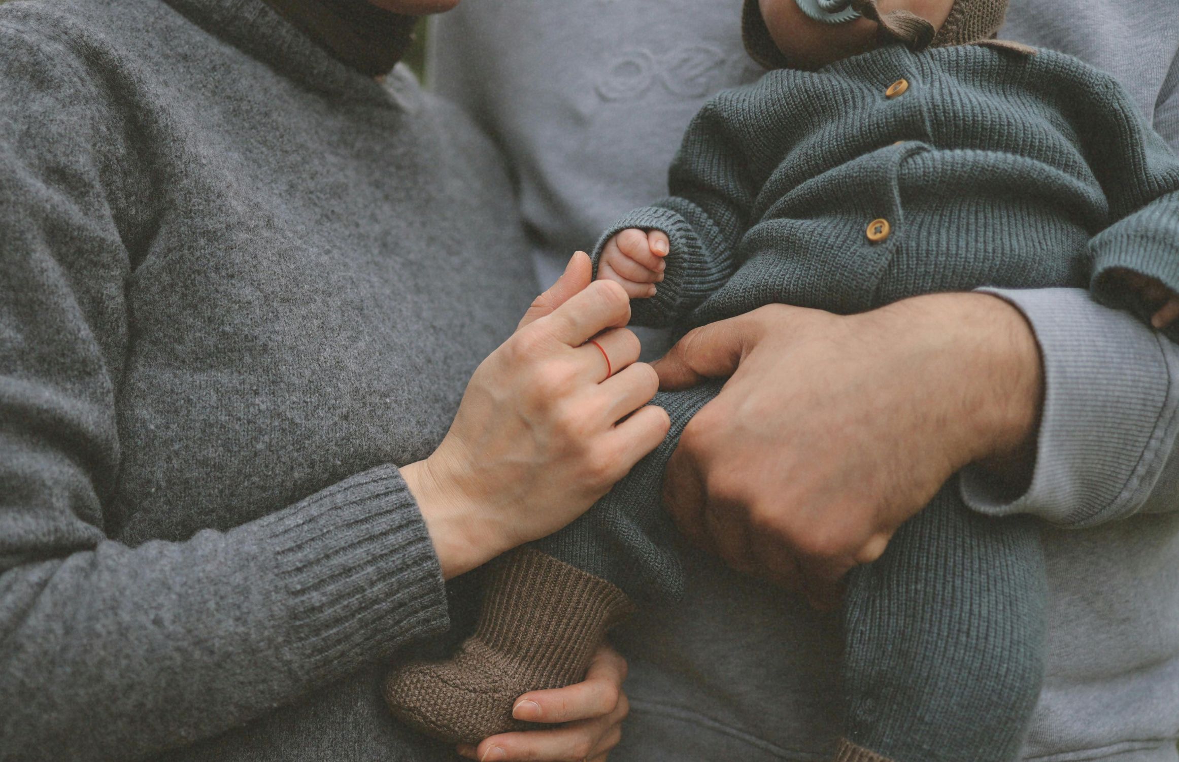 Parents holding a baby’s hand