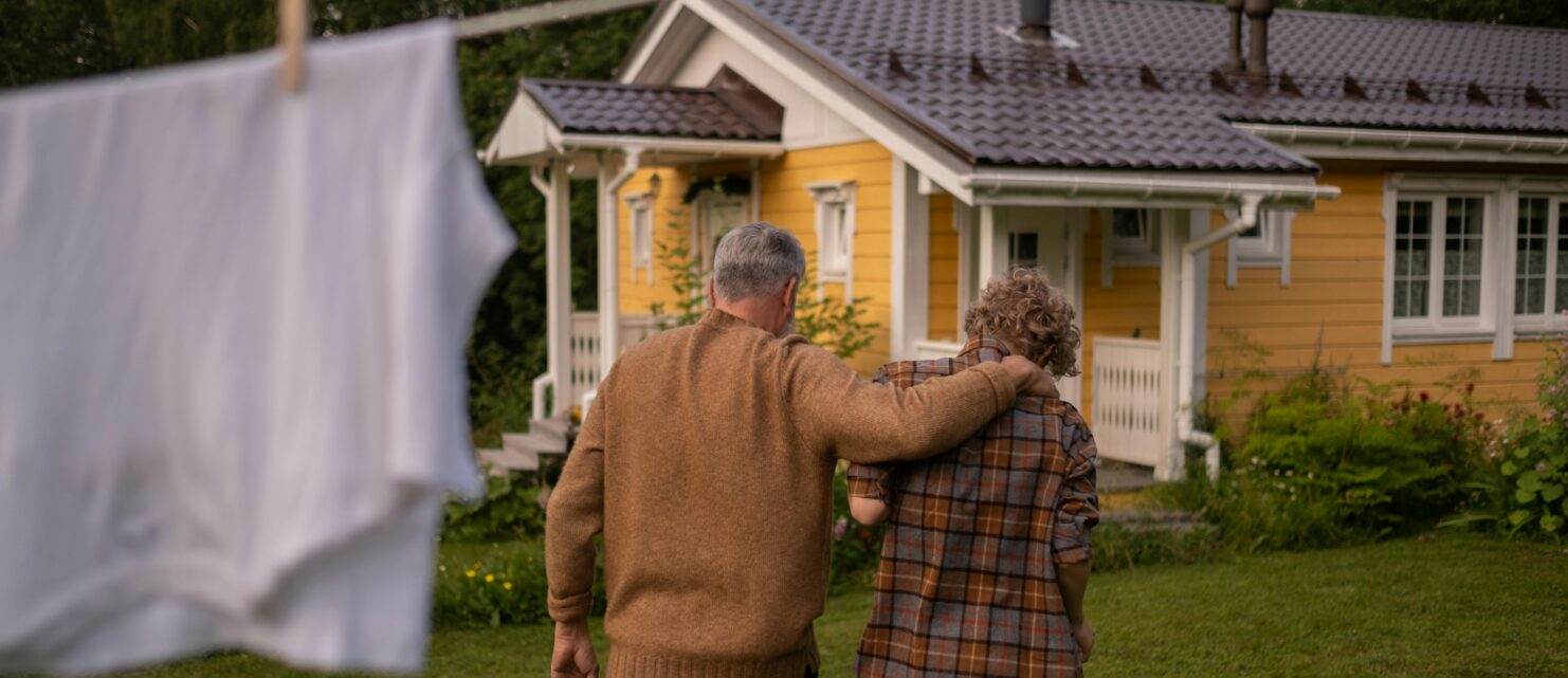 Father and son embrace in a hug while walking towards house