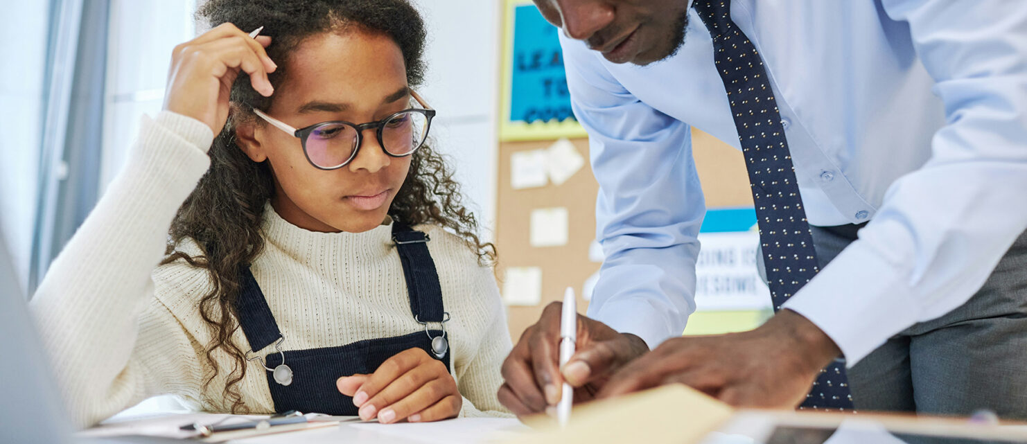 Child works with teacher on classwork