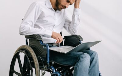 blog-hero-assistive-technology-tbi-wheelchair-8127985 Man in a wheelchair using a laptop, representing assistive technology and independence after a TBI