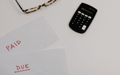 blog-hero-lifetime-cost-tbi-sci-calculator-7111490 Calculator and paid/due bills on a desk, representing the lifetime financial cost of traumatic brain injury and spinal cord injury