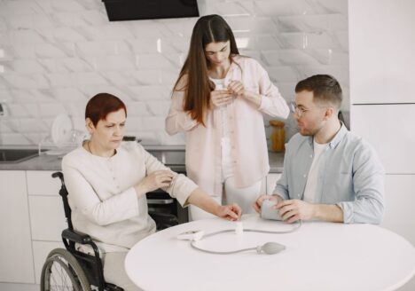 Caregiver helping a family member in a wheelchair at home, representing Medicaid home and community-based care after a TBI