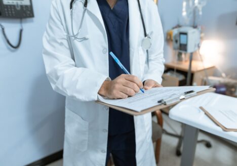 Doctor writing on a medical chart, representing documentation of care in a medical negligence case